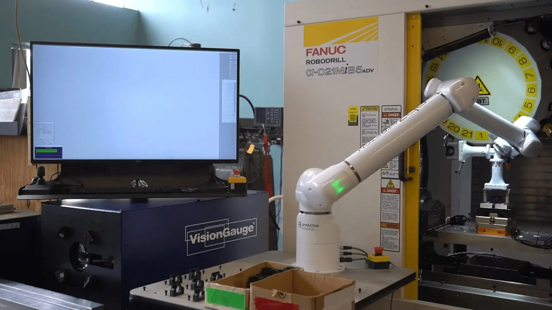 A cobot arm loads a machined part onto a VisionGauge system for automatic inspection.